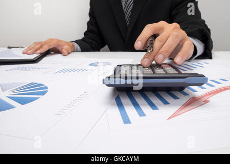Asian Business man using a calculator to calculate the numbers Stock Photo