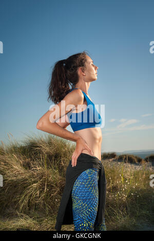 woman resting after running and exercise in sand dunes Stock Photo