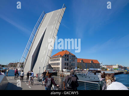 The Trangrav Bridge,Trangravsbroen, a Butterfly 3-Way cyclist and pedestrian bridge across Christianshavn Canal opens for a boat. Copenhagen, Denmark. Stock Photo