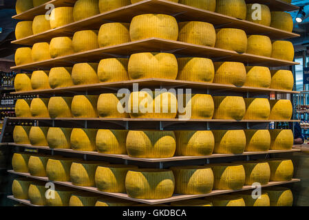Wheels of Parmigiano-Reggiano or Parmesan cheese on the shelves of Ghiaia market in Parma. Emilia- Stock Photo