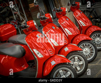 Red motor scooters for sale at a Vespa dealership in Paris, France Stock Photo