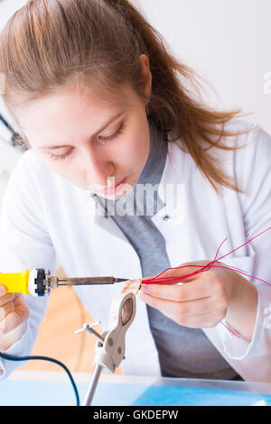 Girl assembling works soldering iron Stock Photo