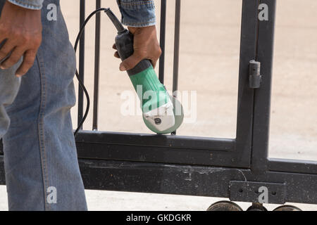 hand of worker using an angle grinder to grinding door frames Stock Photo