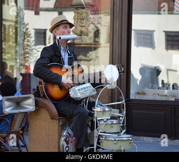 Street musician performing on multiple instruments. Stock Photo