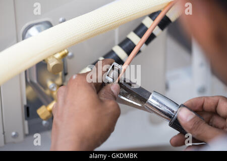 worker cutting the copper pipe of air conditioner Stock Photo