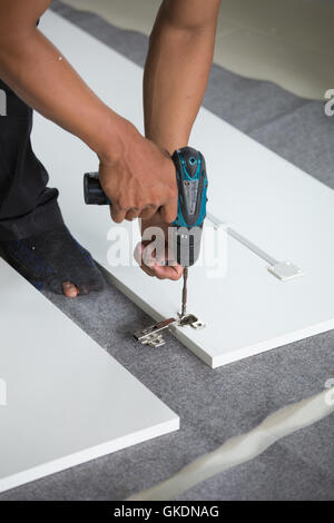 Assembling new furniture with a screwdriver Stock Photo
