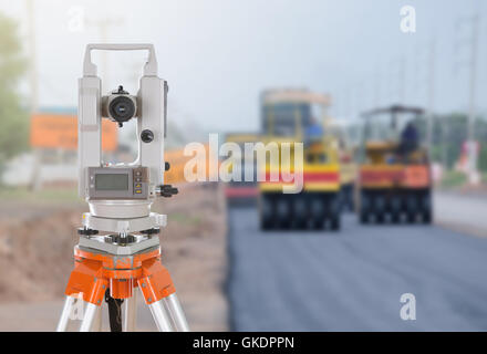 Survey equipment theodolite on a tripod. with road under construction background Stock Photo
