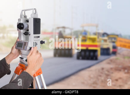 hand working with survey equipment theodolite on a tripod. with road under construction background Stock Photo