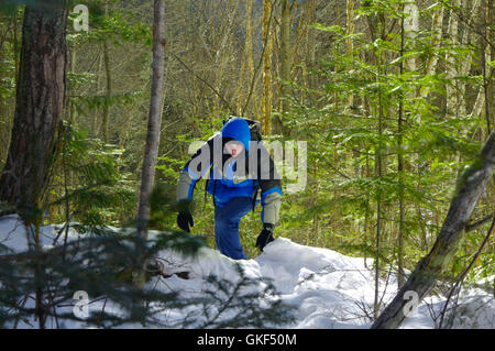 man goes through the woods on snowshoes Stock Photo