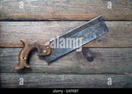 retro rusty crosscut hand saw handsaw tool isolated on wooden background Stock Photo