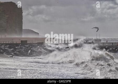 West Bay, Dorset, UK. 20th August, 2016. Waves crash into West Bay as  summer comes to an abrupt  end on the Dorset coast. Strong winds and large waves coincide with spring tides replacing the idyllic summer weather of the past few weeks with with winds of up to 60 mph, flood warnings and a Yellow Weather alert from the Met Office. Credit:  Tom Corban/Alamy Live News Stock Photo