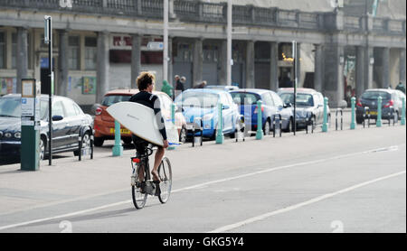 Brighton Sussex UK 20th August 2016 - A surfer heads for the sea in Brighton this morning as gale force winds batter the south coast of Britain unusual for this time of year but the weather is forecast to improve over the next few days with temperatures rising  Credit:  Simon Dack/17�Թ����� Live News Stock Photo