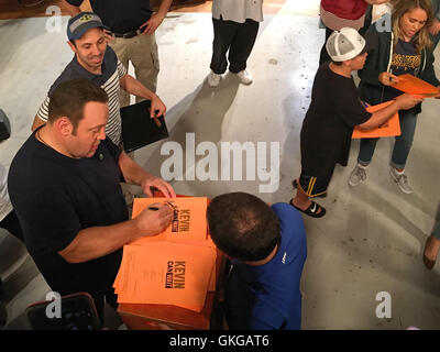 Bethpage, New York, USA. August 19, 2016. Actors KEVIN JAMES (bottom left) and children JAMES DIGIACOMO and MARY-CHARLES JONES (upper right) - cast members of CBS new sitcom 'Kevin Can Wait' - are autographing copies of script cover of 1st episode, after filming is done. The Sony Pictures Television Inc show is first TV series to be shot entirely on Long Island, and is filmed at Gold Coast Studios, and is set to premiere September. Credit:  Ann E Parry/Alamy Live News Stock Photo