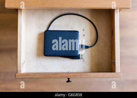 above view of external hard drive in open drawer of nightstand Stock Photo