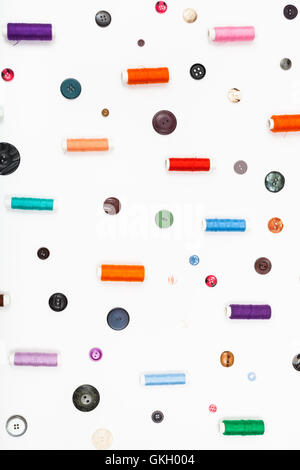 many spools of thread and different buttons on white background Stock Photo