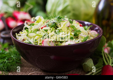 Vitamin salad of young vegetables: cabbage, radish, cucumber and fresh herbs Stock Photo