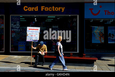 Young man holding up sign advertising breakfasts and a local café, Darlington, County Durham, England UK Stock Photo