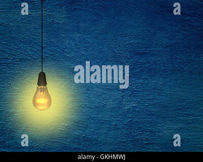 Close-up of one yellow turned on light bulb on blue concrete wall background Stock Photo
