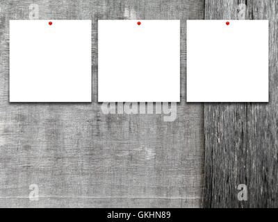 Close-up of three square blank frames with red pins on gray wooden boards background Stock Photo