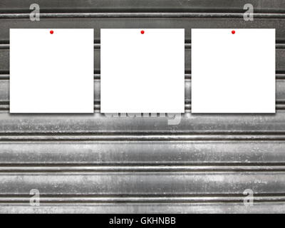 Close-up of three square blank frames with red pins on gray old metal shutter background Stock Photo