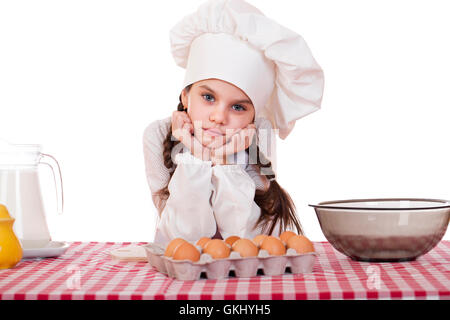 Little girl in a white apron near the box with eggs, isolated on white background Stock Photo