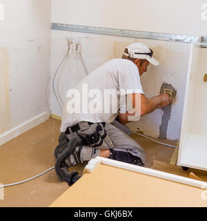 Carpenter mounting an IKEA kitchen Stock Photo