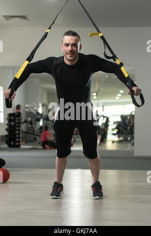 Man Does Crossfit exercise With Trx Fitness Straps In Gym Stock Photo ...
