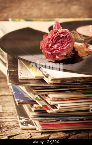 dry rose on a pile of old vinyl records in vintage style Stock Photo