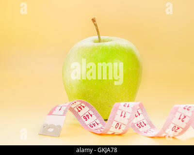 Measuring tape and green apple as a symbol of diet Stock Photo