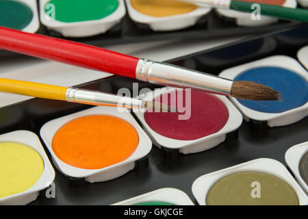 new unused palette of multicolor watercolor paints with paint brushes Stock Photo
