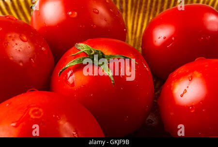 still life - ripe small tomatoes on brown plate Stock Photo