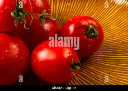 still life - ripe small tomatoes on brown plate Stock Photo