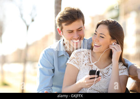 Couple listening to the music from a smart phone Stock Photo