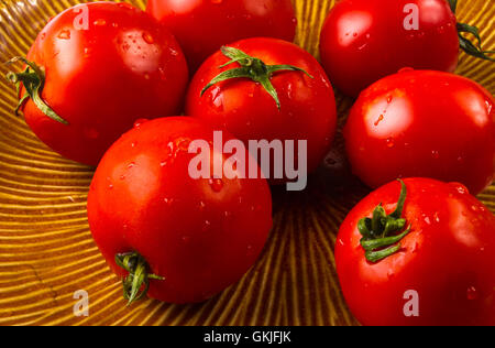 still life - ripe small tomatoes on brown plate Stock Photo