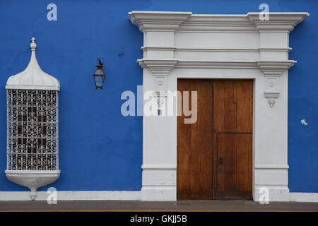 Imposing wooden door to bright blue and white Spanish colonial style building in the Plaza de Armas in Trujillo, Peru. Stock Photo