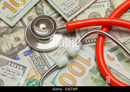 Red Stethoscope with a Pile of Hundred Dollar Bills. Stock Photo