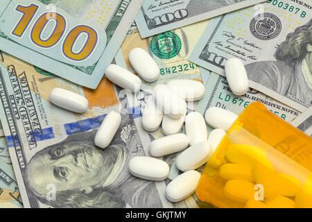 Spilled Bottle of Pills on Top of a Pile of Money. Stock Photo