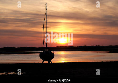 horizontal photo of yacht in silhouette at sunset Stock Photo