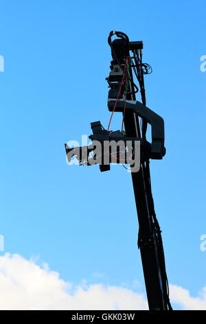 Professional TV camera on a crane against sky. Stock Photo