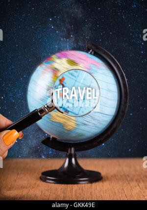 globe and magnifying glass standing on the table Stock Photo