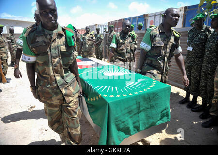 AMISOM UPDF soldiers carry the coffin of one of their fallen commrades during the repatriation ceremony of 3 AMISOM soldiers who died during the attack on the Somalia parliament building by Alshabaab terrorists on 24th May 2014 in Mogadishu. AMISOM Public Information Services / David Mutua Stock Photo