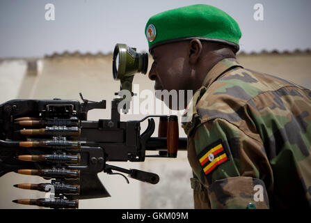 SOMALIA, Mogadishu: In a handout photograph released by the United Nations-African Union Information Support Team, a Ugandan officer serving with the African Union Mission in Somalia (AMISOM) ranges a scope on a heavy machine-gun mounted on the roof of Mogadishu University 23 January. AMSIOM and Somali National Army (SNA) forces have consolidated newly captured positions, including the the strategically important university, following a major joint offensive to oust the insurgent group Al Shabaab from remaining pockets of Mogadishu and for the first time sees AMSIOM occupying positions and ter Stock Photo