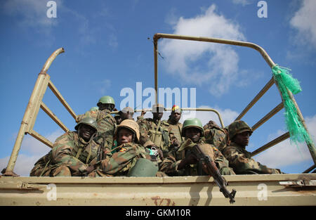 SOMALIA, Afgoye: In a photograph dated 26 May and released by the African Union-United Nations Information Support Team 27 May, Ugandan soldiers serving with the African Union Mission in Somalia (AMISOM) are seen on the the back of a military truck in the town of Afgoye to the west of the Somali capital Mogadishu as they prepare to deploy south of the town on the road to Merka. An joint-AMISOM and Somali National Army (SNA) offensive has driven the Al-Qaeda-affiliated extremist group Al Shabaab from the strategically important area of the Afgoye corridor, which the group used as a base to laun Stock Photo