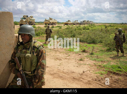 SOMALIA, Afgoye: In a photograph dated 26 May and released by the African Union-United Nations Information Support Team 27 May, Ugandan soldiers serving with the African Union Mission in Somalia (AMISOM) are seen beside a convoy along the road leading south from the town of Afgoye to the west of the Somali capital Mogadishu. An joint-AMISOM and Somali National Army (SNA) offensive has driven the Al-Qaeda-affiliated extremist group Al Shabaab from the strategically important area of the Afgoye corridor, which the group used as a base to launch attacks inside Mogadishu and is also home to hundre Stock Photo