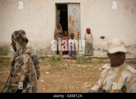 SOMALIA, Balad: In a photograph taken 01 August and released by the African Union-United Nations Information Support team 02 August, children look on as Somali security personel patrol during a visit by President Sheik Sharif Sheik Ahmed to Balad town in Middle Shabelle region approx. 40km north east of the capital Mogadishu. Balad was until recently, under the control of the Al-Qaeda-affliated terrorist group Al Shabaab until an offensive by the Somali National Army (SNA) supported by the African Union Mission in Somalia (AMISOM) forces on 26 June drove out the extremists, liberating the town Stock Photo