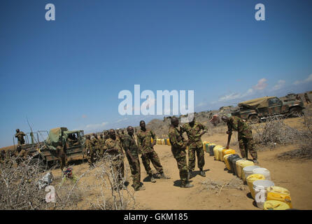 SOMALIA. Saa'moja / Kisamayo: In a handout photograph released by the African Union-United Nations Information Support Team 01 October, soldiers of the Kenyan Contingent serving with the African Union Mission in Somalia (AMISOM) wait to refill water containers in Saa'moja, an area approx. 7km outside the Somali port city of Kismayo. For the last two months, AMISOM's Kenyan Contingent in support of the Somali National Army (SNA) has been steadily liberating areas and villages in Southern Somalia formally under the control of the Al Qaeda-affiliated extremist group Al Shabaab, which has brought  Stock Photo