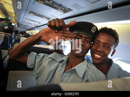 SOMALIA, Mogadishu: In a handout photograph dated 17 January and released by the African Union-United Nations Information Support Team 18 January, two officers of the Somali Police Force (SPF) gesture on-board an aircraft at Aden Abdulle International Airport in the Somali capital Mogadishu for a three-month training course in Djibouti organized by the Police component of the African Union Mission in Somalia in conjunction with the Italian Carabineri. The 184 Men and 16 women will receive specialized training in Public Order Management facilitated by the African Union Mission in Somalia (AMISO Stock Photo