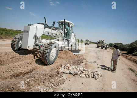 SOMALIA, Mogadishu: In a photgraph taken 24 January and released by the African Union-United Nations Information Support Team 26 January, African Union Mission in Somalia (AMISOM) combat engineers grade a stretch of road leading to the town of Afgooye in Somalia's Lower Shabelle region along the main route linking the fertile, agricultural region with the capital Mogadishu. After years under the control of the violent extremist Al-Qaeda linked group Al Shabaab, stretches of the economically  important thoroughfare were virtually in-passable. Now, 7 months after the Shabaab were forced to flee  Stock Photo