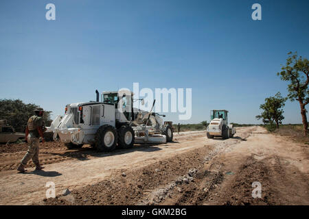 SOMALIA, Mogadishu: In a photgraph taken 24 January and released by the African Union-United Nations Information Support Team 26 January, African Union Mission in Somalia (AMISOM) combat engineers grade and repair a stretch of road leading to the town of Afgooye in Somalia's Lower Shabelle region along the main route linking the fertile, agricultural region with the capital Mogadishu. After years under the control of the violent extremist Al-Qaeda linked group Al Shabaab, stretches of the economically  important thoroughfare were virtually in-passable. Now, 7 months after the Shabaab were forc Stock Photo