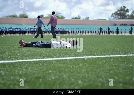 A young boy lies on the astroturf at Konis Stadium at Konis Stadium in Mogadishu, Somalia, during celebrations to mark the country's Independence Day on July 1. Today's celebrations mark 53 years since the Southern regions of Somalia gained independence from Italy and joined with the Northern region of Somaliland to create Somalia. AU UN IST PHOTO / TOBIN JONES. Stock Photo